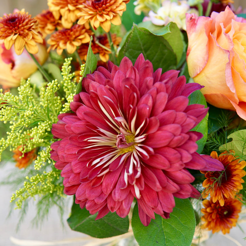 Bouquet of flowers with a prominent pink flower in the center.