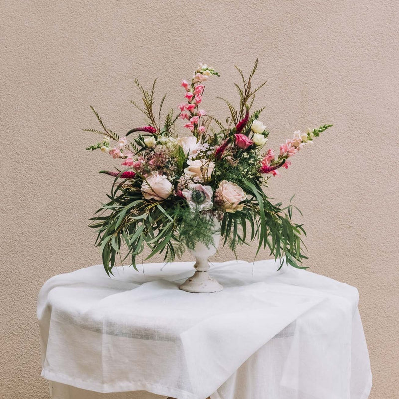 This exquisite blend of lush, textured foliage, vibrant deep pink snapdragons, and delicate light pink anemones crafts an elegant arrangement that radiates joy. Named for a southeast Georgia town celebrated for its captivating charm and tight-knit community spirit.