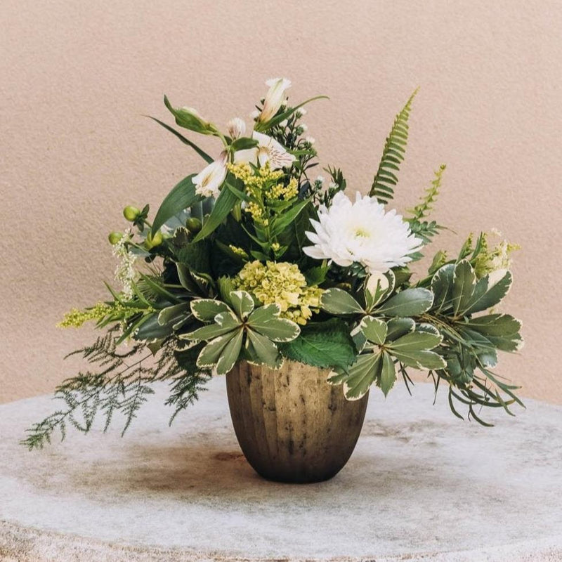 A spirited arrangement bursts with verdant green and crisp white hues, blending lush textures in a sleek gold vase. Named for a southeast Georgia city steeped in rich history and with a thriving arts scene.