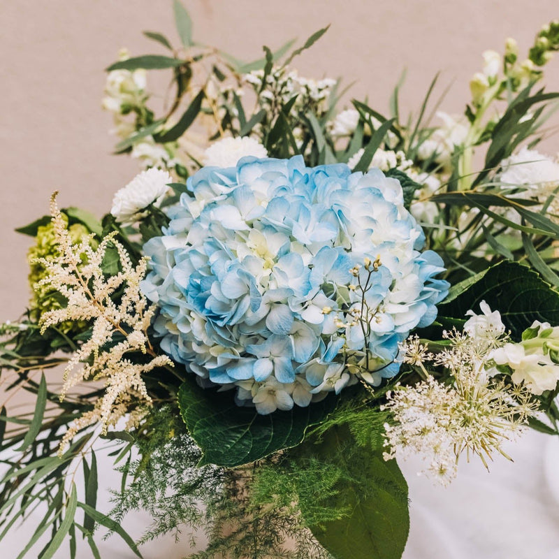A delightful blend of blue and white blossoms graces a footed vase with an antique finish, exuding timeless charm. Named for a vibrant northwest Georgia city renowned for its pivotal role in the Civil War.