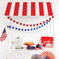 Glitter star banners in red and blue arranged as curved garlands with patriotic 4th of July party styling and red-white striped canopy
