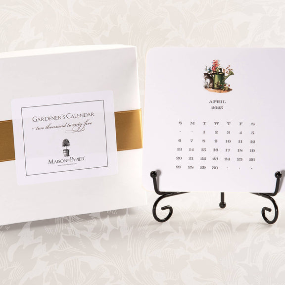 A 2025 calendar with easel, featuring a card with garden motifs for each month, displayed alongside its packaging.