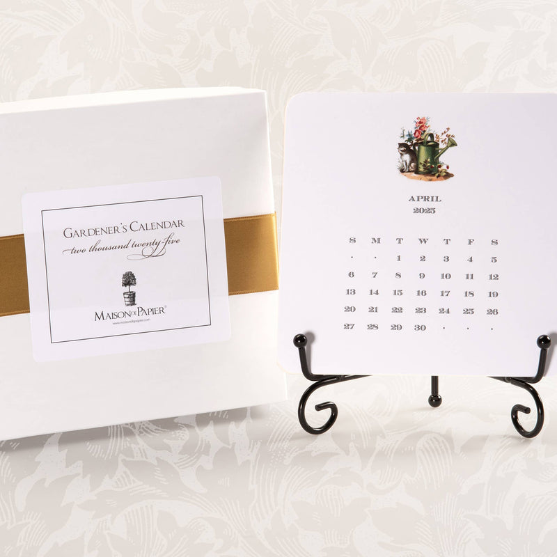 A 2025 calendar with easel, featuring a card with garden motifs for each month, displayed alongside its packaging.