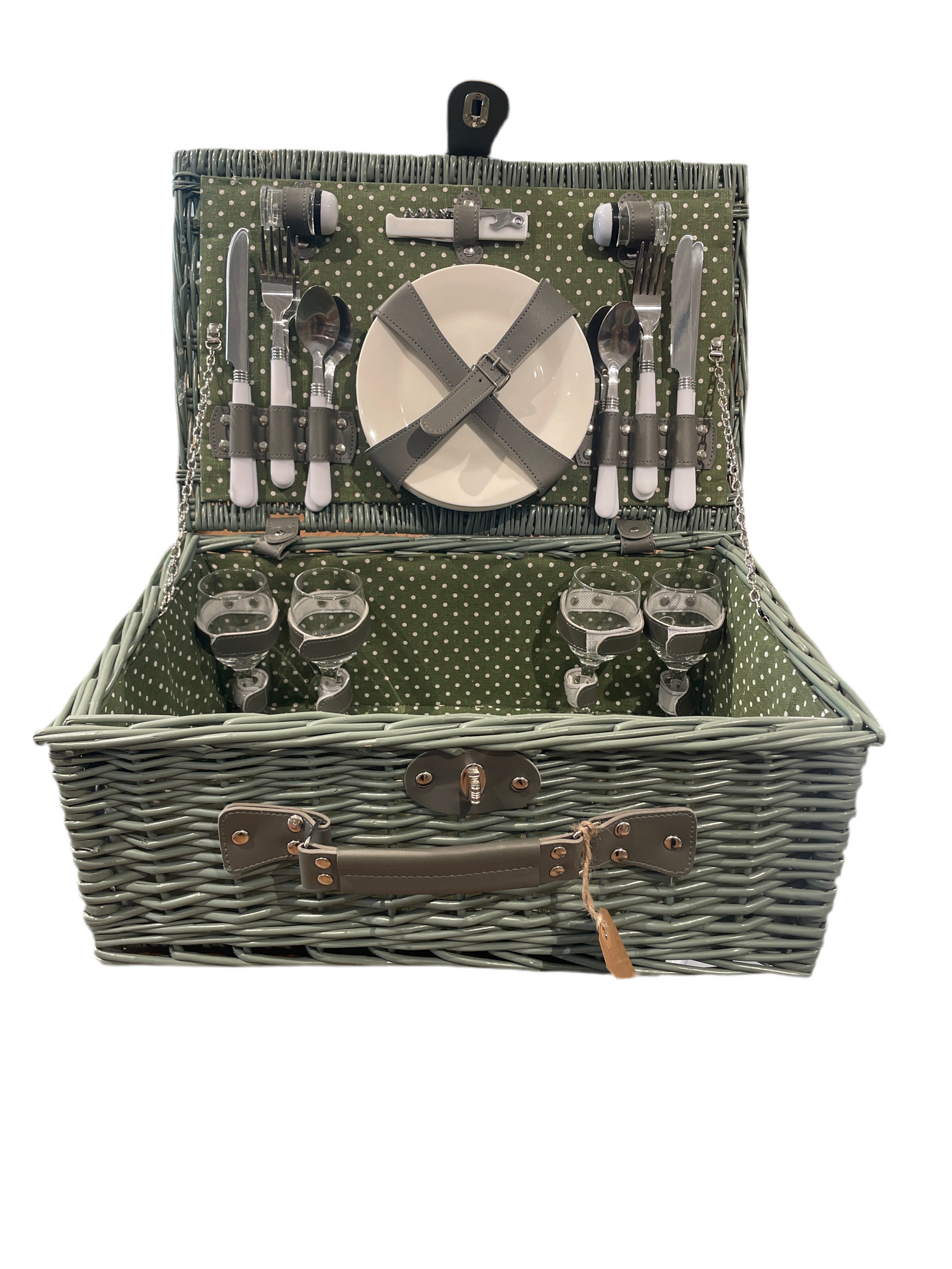 Open woven wicker picnic basket with polka-dot green interior, showing complete service set for four with plates, glasses, cutlery, and accessories