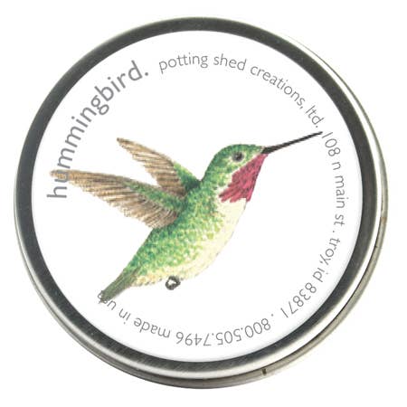 Hummingbird seed packet by Potting Shed Creations with illustrated green and red hummingbird in flight on white circular label with metallic rim.