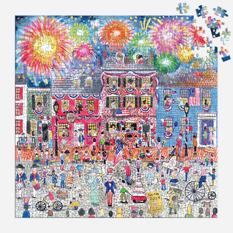 Celebrate the USA puzzle box displaying vibrant 500-piece jigsaw with Michael Storrings' patriotic boardwalk illustration featuring fireworks, Ferris wheel, crowds, and Americana details