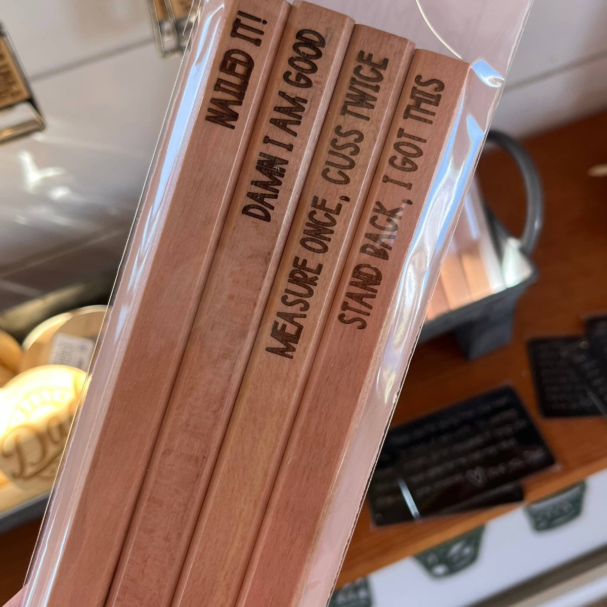 Set of four engraved flat wooden carpenter pencils in clear plastic packaging, unsharpened and ready to customize.