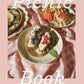 Cottage-core picnic book cover with plated toasts topped with berries, greens, and whipped cream on pink gingham fabric.