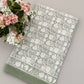Sage green cotton tablecloth with white botanical floral and leaf print pattern and tonal border detail.