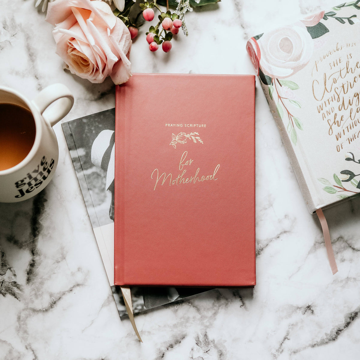 Coral hardcover prayer journal with gold foil lettering for motherhood, styled on marble with fresh roses, coffee, and handwritten notes