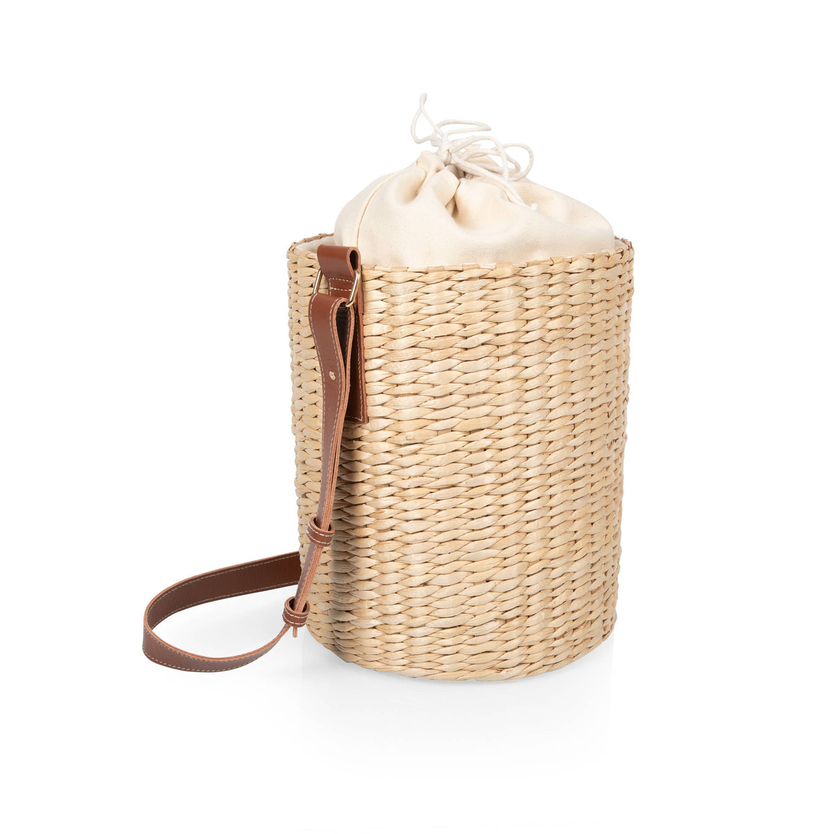 Beige handwoven rush bucket tote with cream drawstring top and adjustable leather shoulder strap.