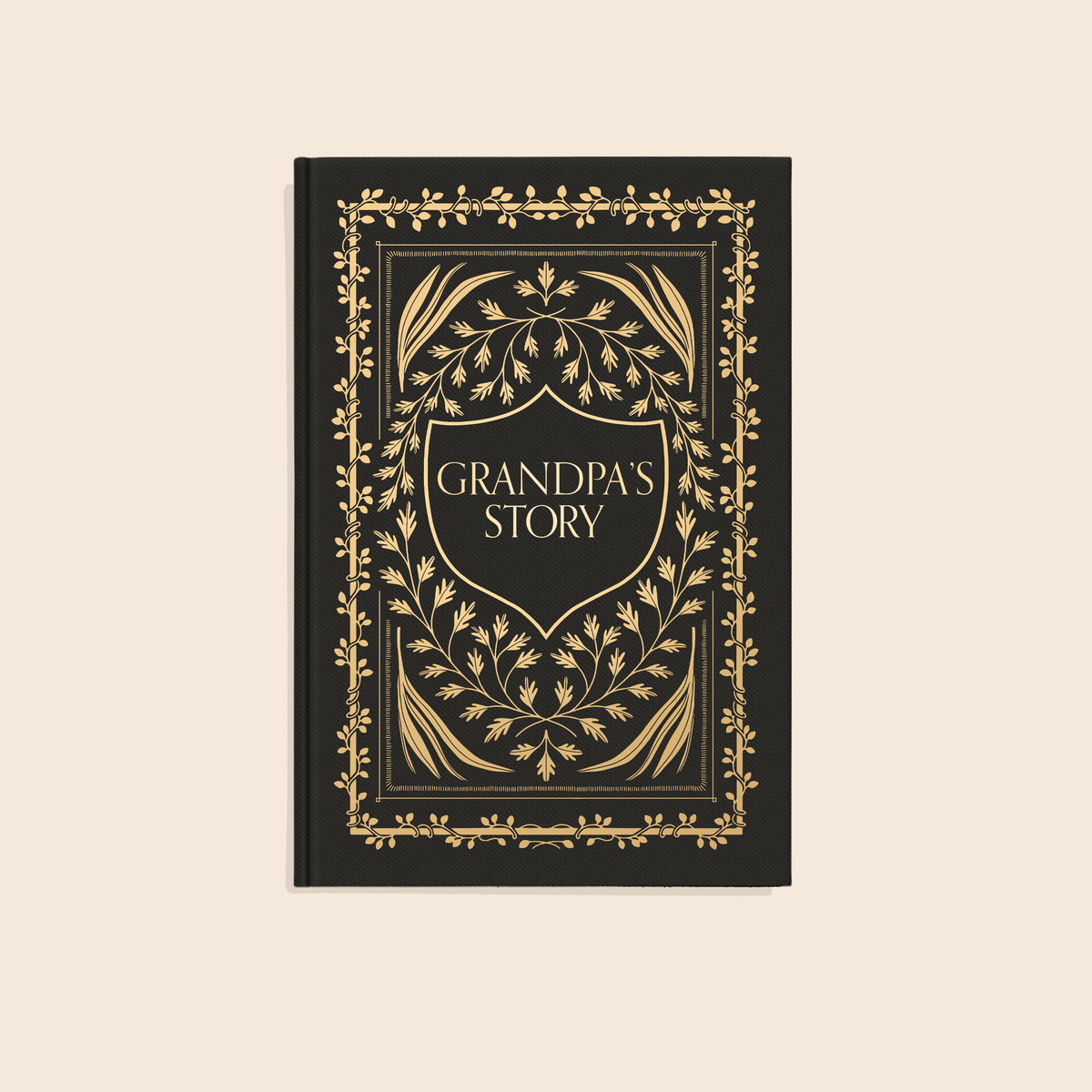 Black hardcover journal with gold foil botanical border and shield-shaped panel reading "Grandpa's Story"