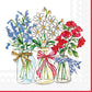 Three glass jars filled with patriotic flowers—blue delphinium, white daisy-like blooms, and red poppies—each tied with coordinating ribbons in gold, red, and blue
