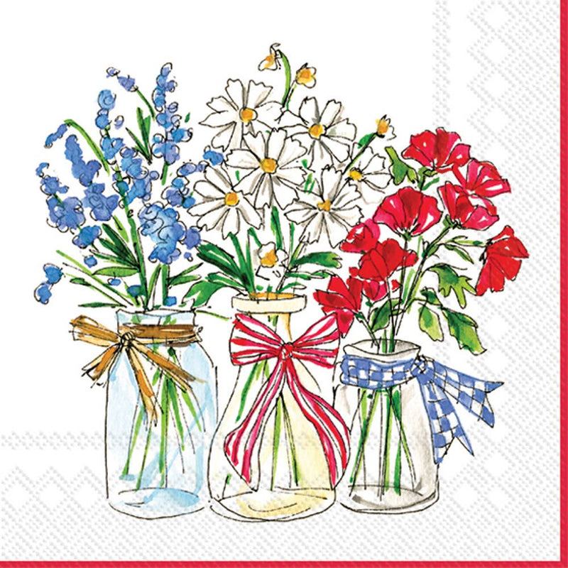 Three glass jars filled with patriotic flowers—blue delphinium, white daisy-like blooms, and red poppies—each tied with coordinating ribbons in gold, red, and blue