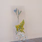 Pressed flower bookmark with blue forget-me-nots, yellow yarrow, and pale blue baby's breath on clear acrylic stand.