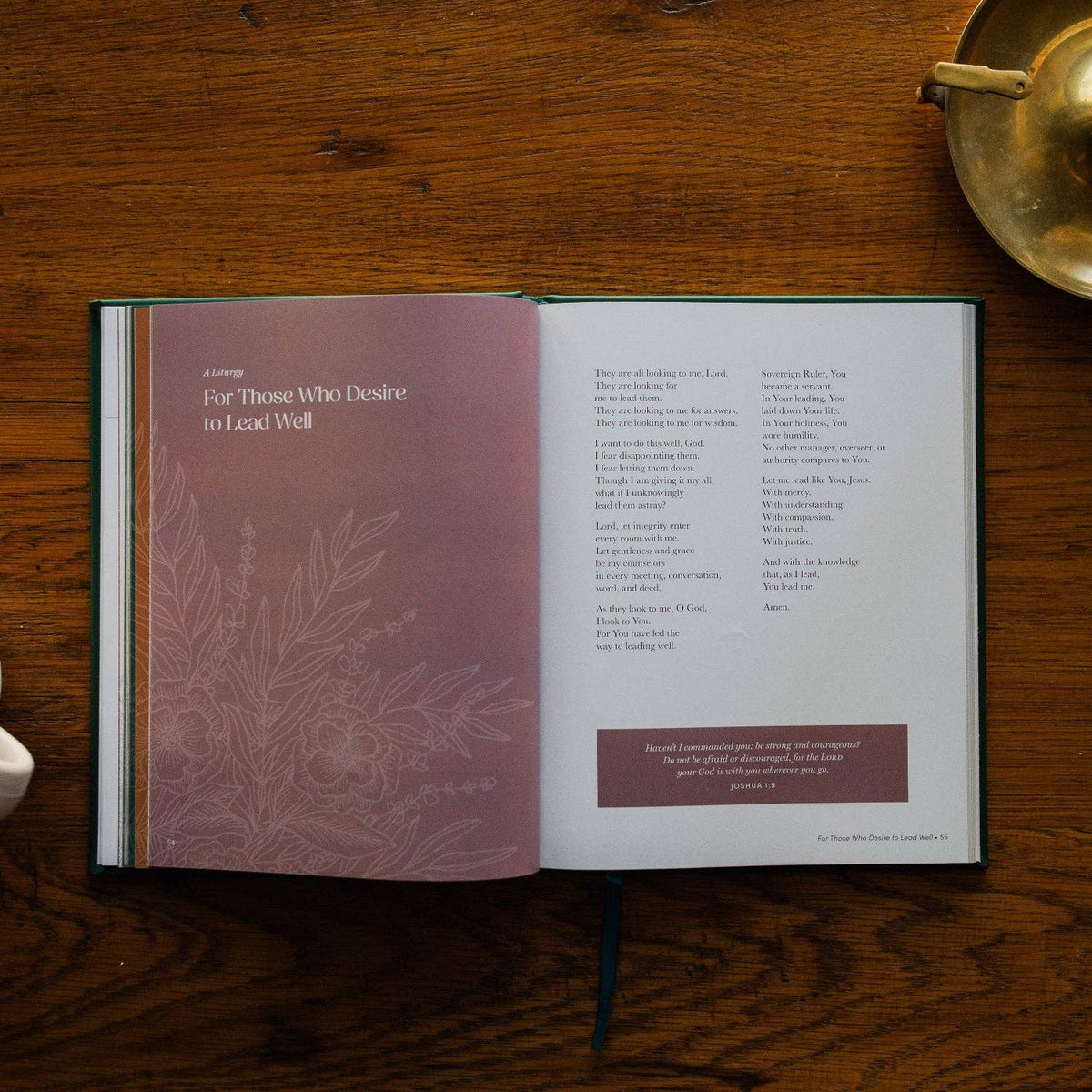 Open book titled 'For Those Who Desire to Lead Well' with mauve and white pages on rich wood surface, brass bowl in background.