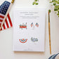 White notecard box displaying four Americana-themed watercolor illustrations: flower wagon, crossed flags in vase, red bunting, and hydrangea