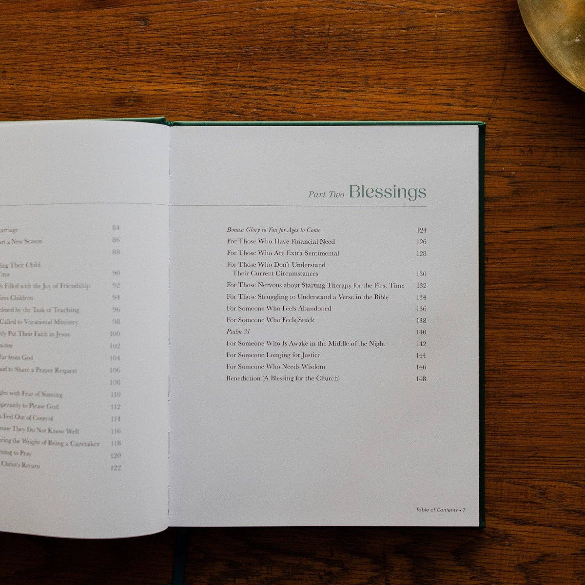 Open book on wood showing table of contents for "Part Two: Blessings" with prayer and liturgy entries and page numbers.