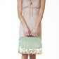 Cream and green polyester picnic blanket with daisy floral pattern, folded with green carry handle