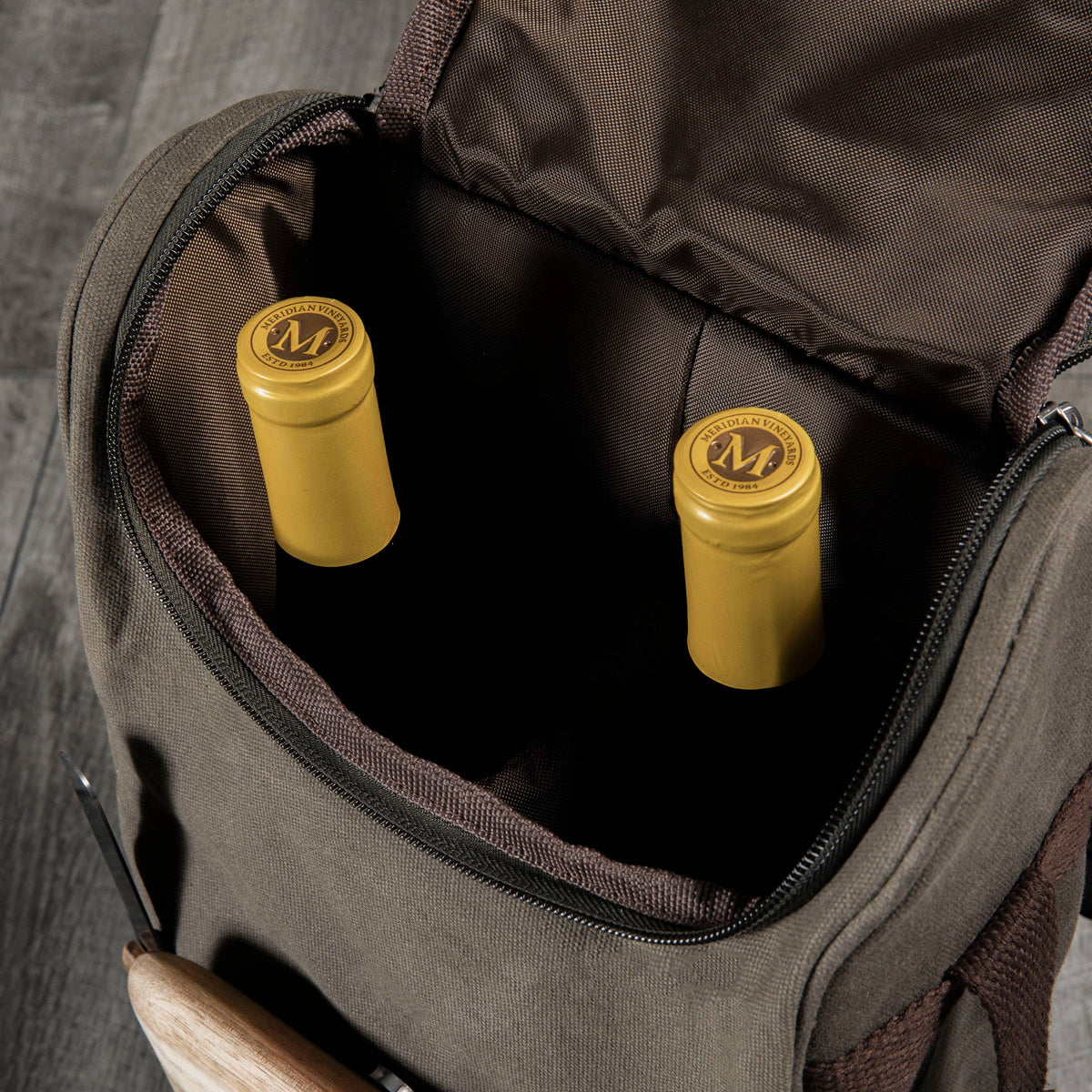 Gray insulated wine tote with 2-bottle capacity, open to reveal interior holding yellow-capped wine bottles with branded seals.