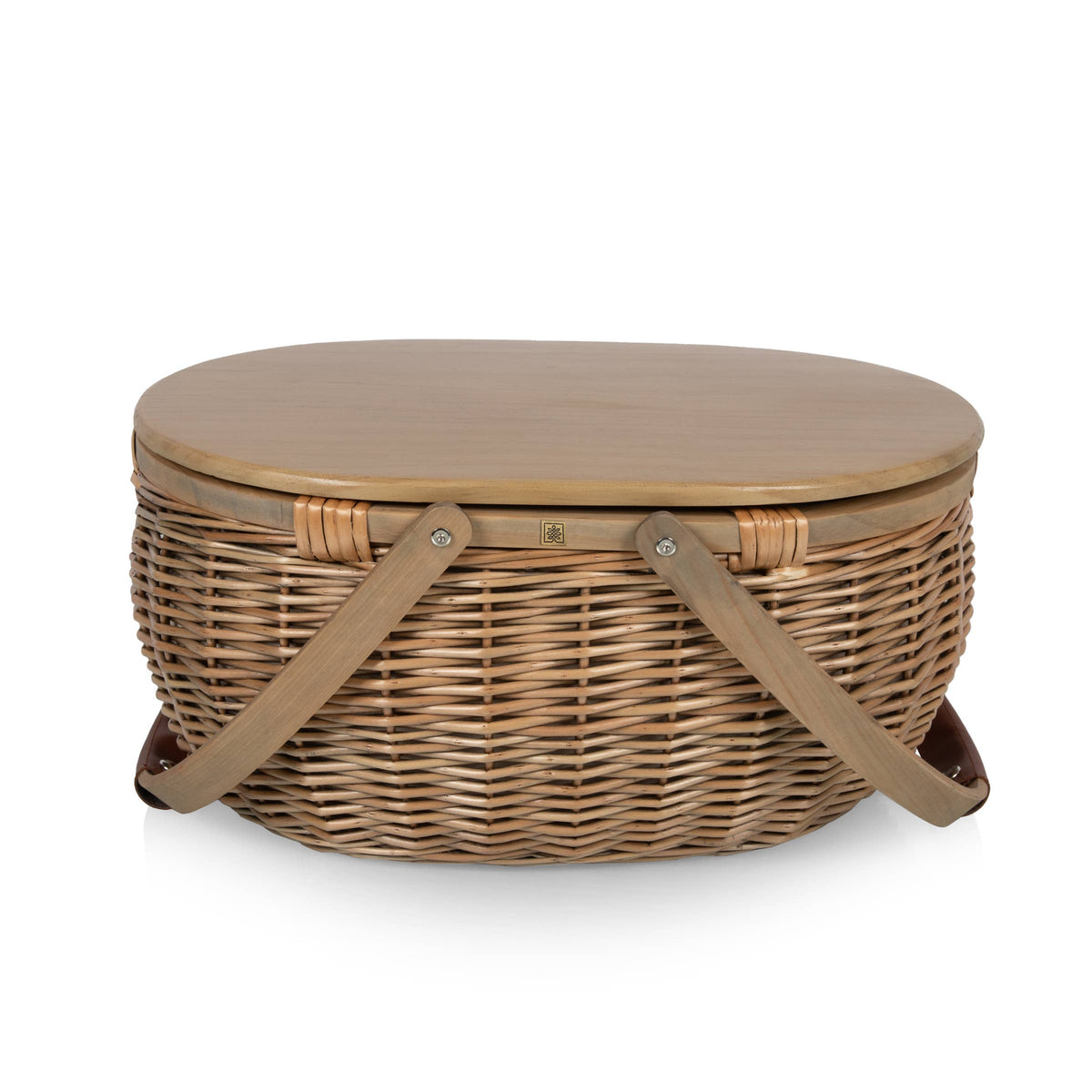 Beige wicker picnic basket with closed lid, dual leather carrying handles, and metal fasteners, shown against white background.