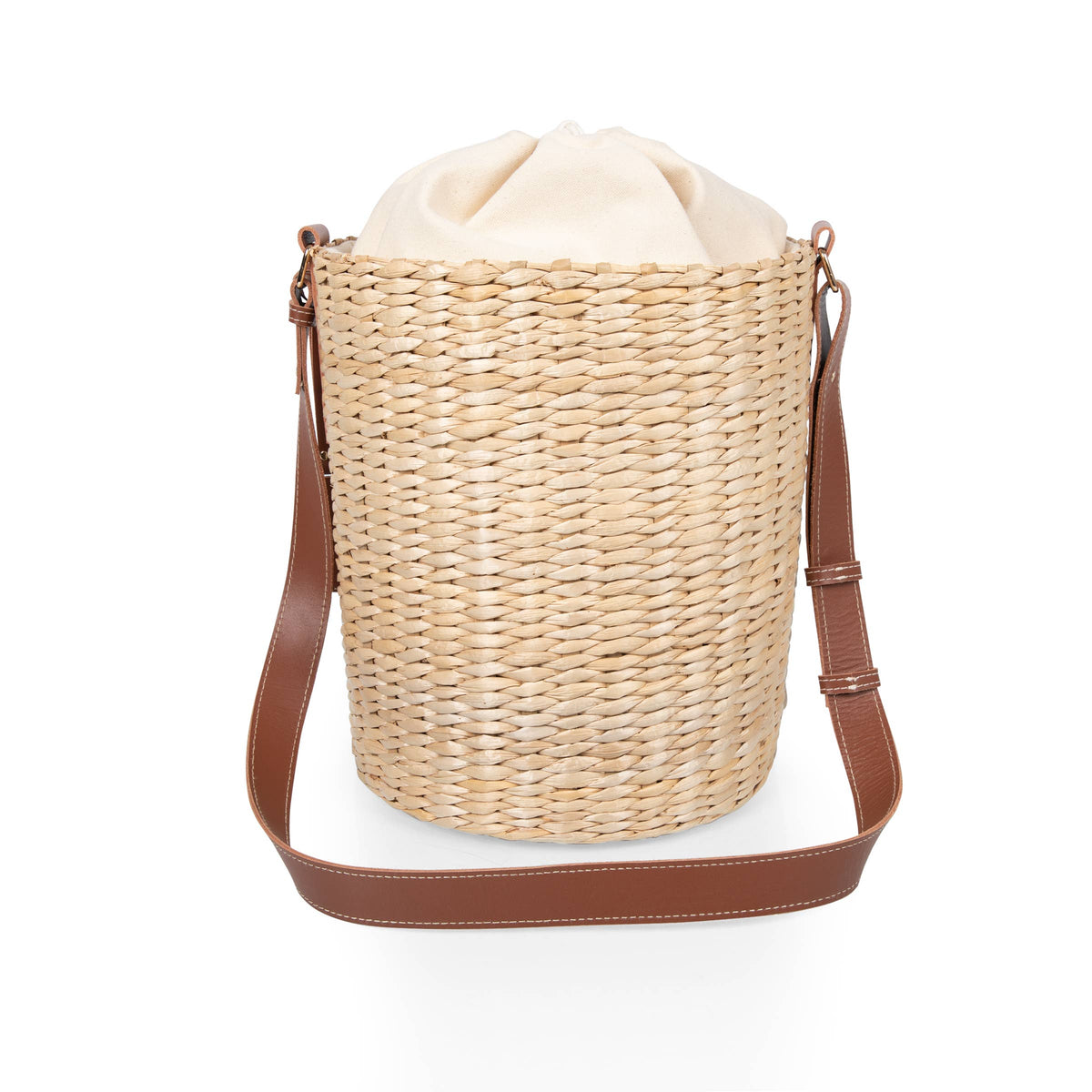 Beige handwoven rush bucket tote with cream canvas lining and brown leather shoulder strap