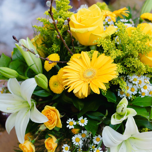 Bouquet of yellow and white flowers with greenery
