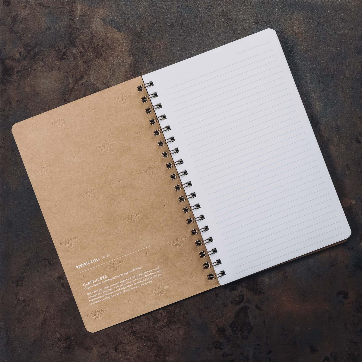 Taupe spiral journal with lined pages open, showing cream colored cover and black binding coils.