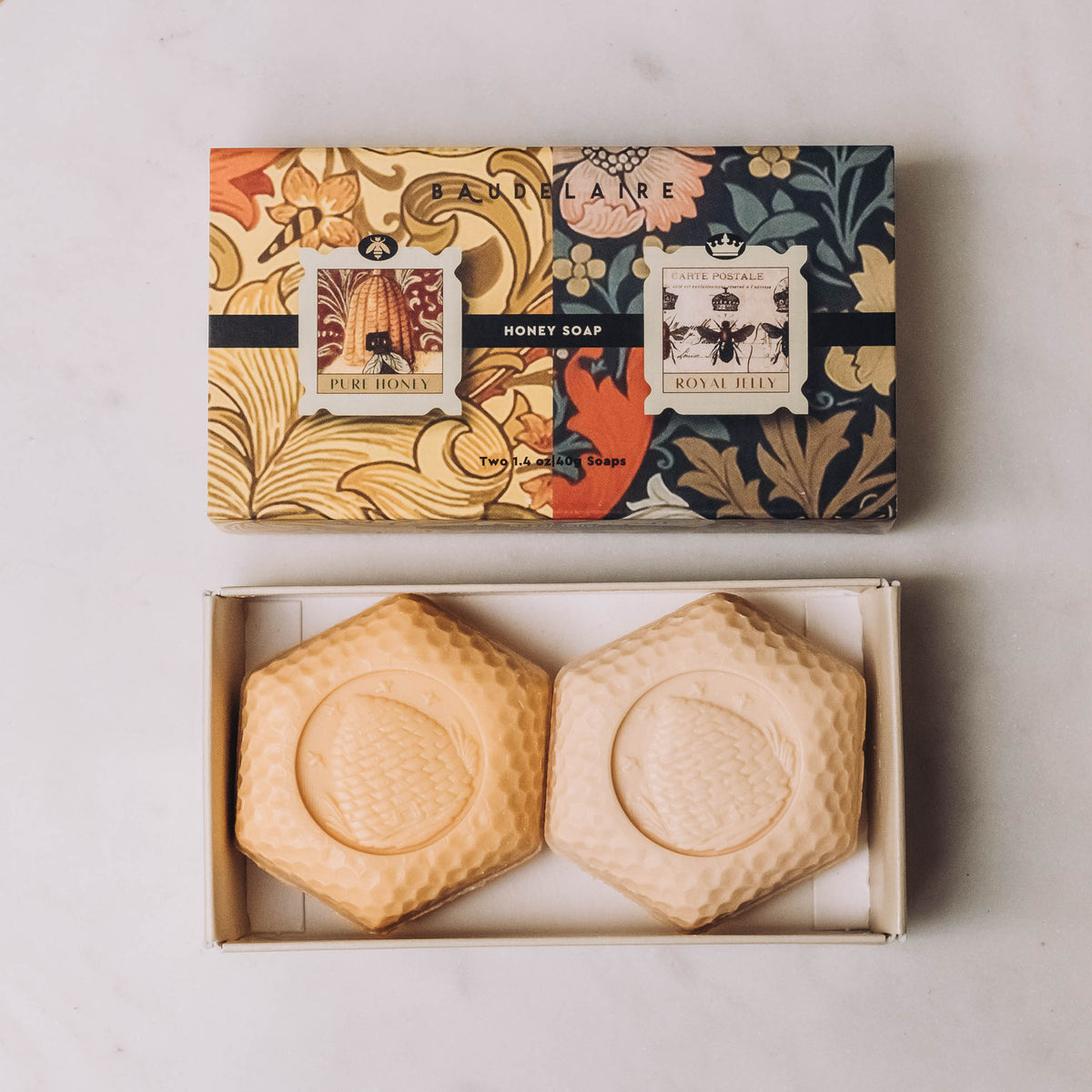 Honey Soap Matchbox Duos featuring two hexagonal bar soaps with honeycomb texture in cream and pale gold, displayed in open box beneath patterned packaging.