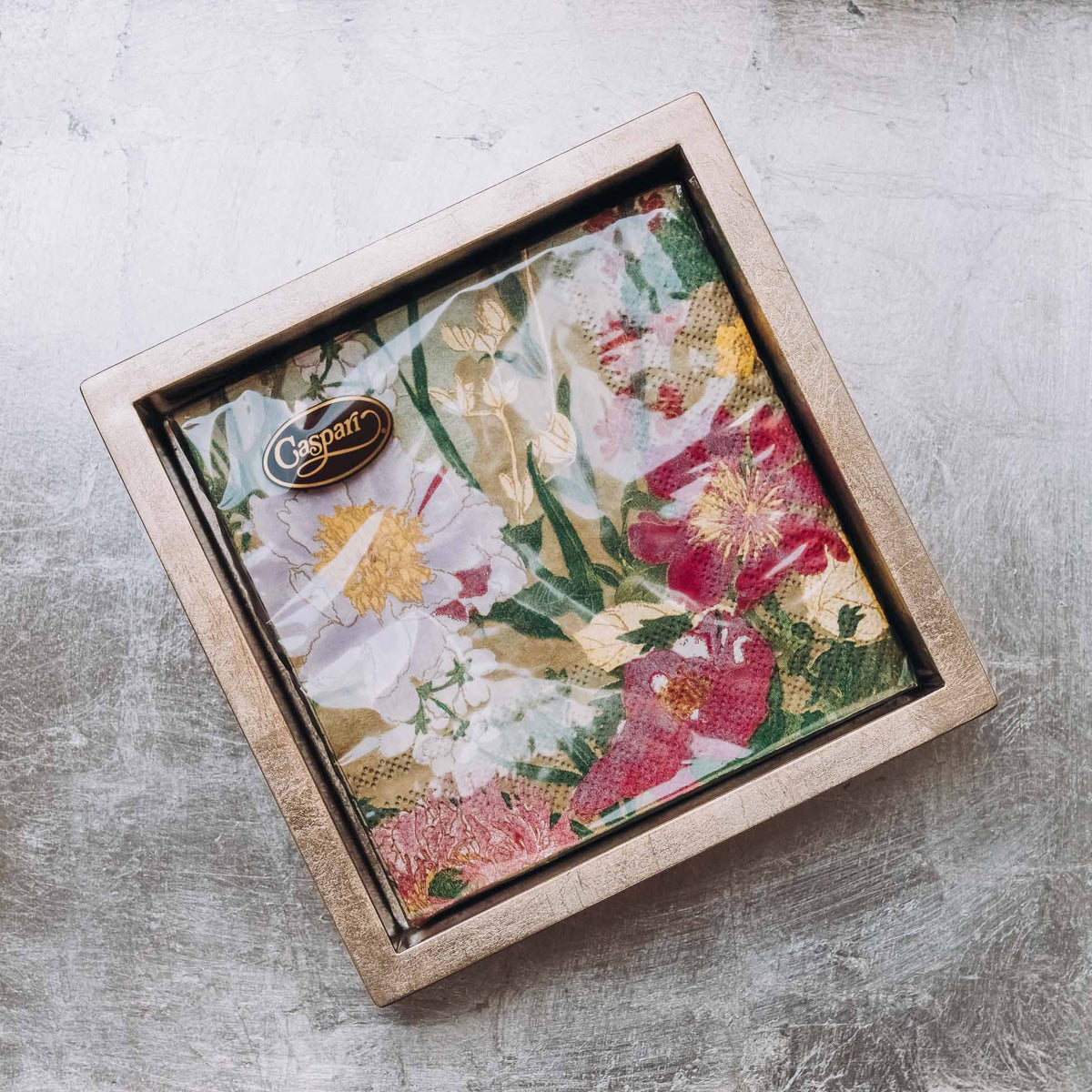 Boxed set of Caspari cocktail napkins with botanical floral print in pink, red, and yellow flowers on cream linen
