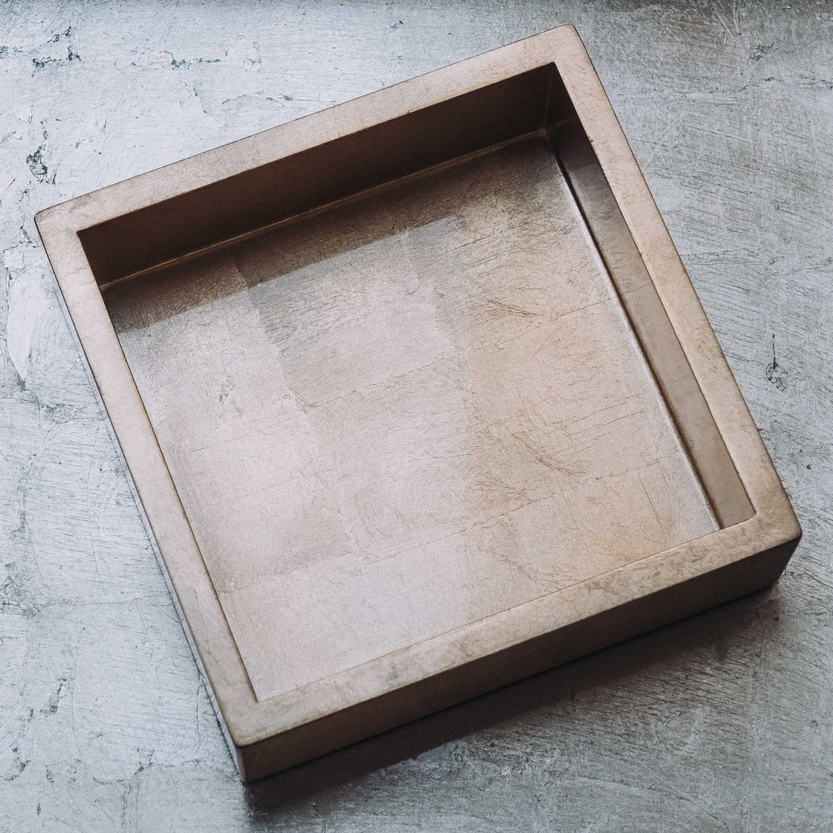 Square wooden napkin holder with natural wood exterior and dark interior divider creating two compartments for cocktail napkins