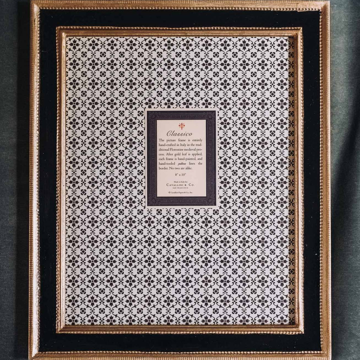 Black wooden Cavallini frame with gold leaf trim and cream geometric patterned mat