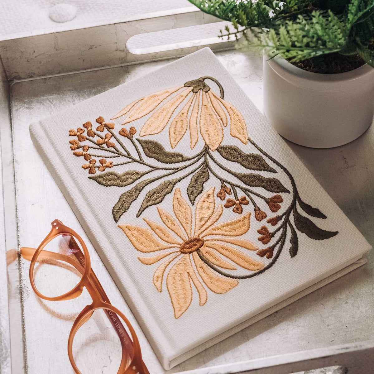 Cream hardcover journal with embroidered orange and yellow echinacea flowers and green foliage
