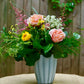 Floral arrangement in a vase on a table with a wooden background