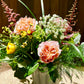 Bouquet of flowers in a white vase against a wooden background