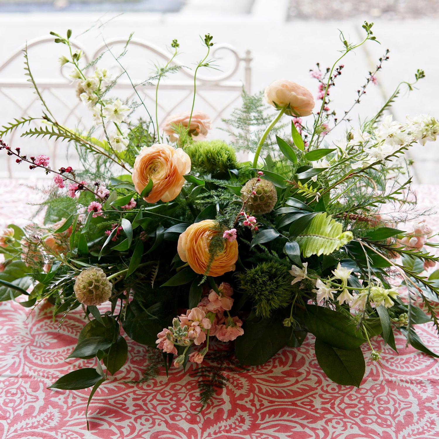 Floral arrangement on a patterned tablecloth with a blurred background