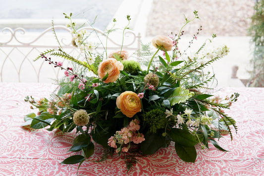 Floral arrangement on a patterned tablecloth with a blurred background