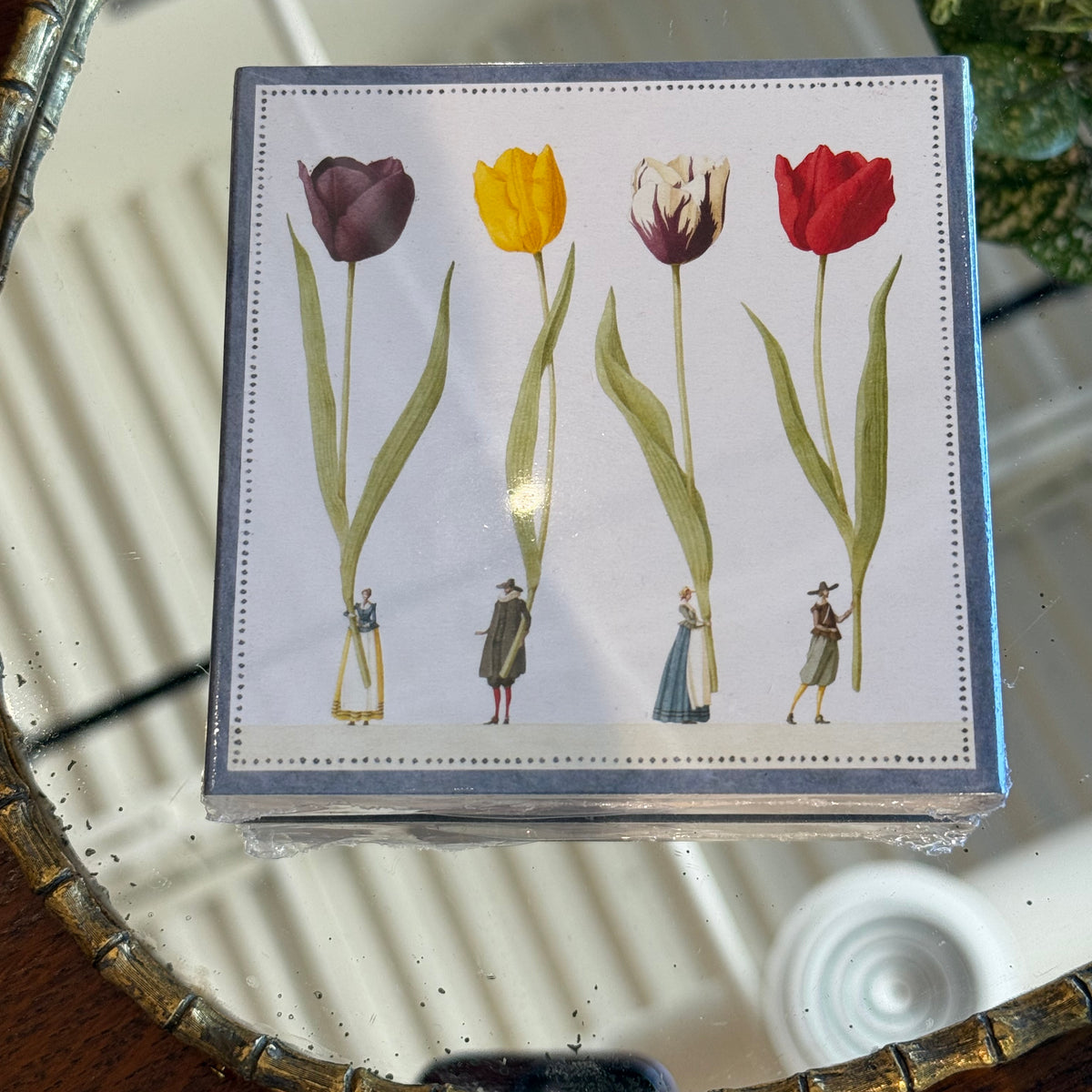 Box of Hester & Cook matches with illustration of four colorful tulips in burgundy, yellow, cream, and red, each held by a small vintage-dressed figure, against white background with dotted border.