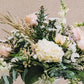 A romantic blend of soft pink and pristine white blossoms, intertwined with lush, luxurious greenery, rests gracefully in a sleek concrete urn, exuding an air of refined elegance. Inspired by a charming central Georgia city, renowned as the backdrop for beloved films like Driving Miss Daisy and Fried Green Tomatoes.