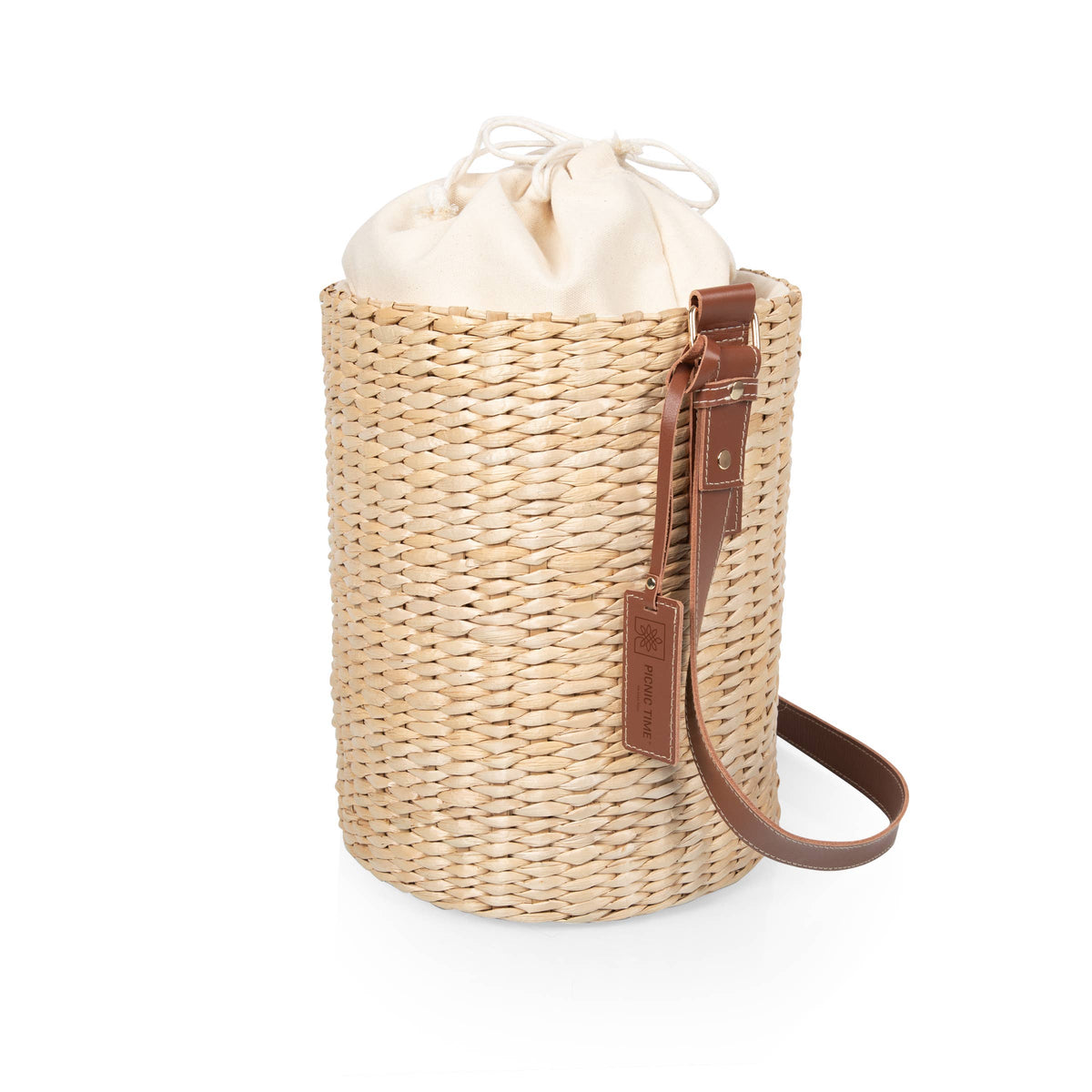 Handwoven beige rush tote with drawstring top and brown leather shoulder strap, insulated bucket-style handbag.