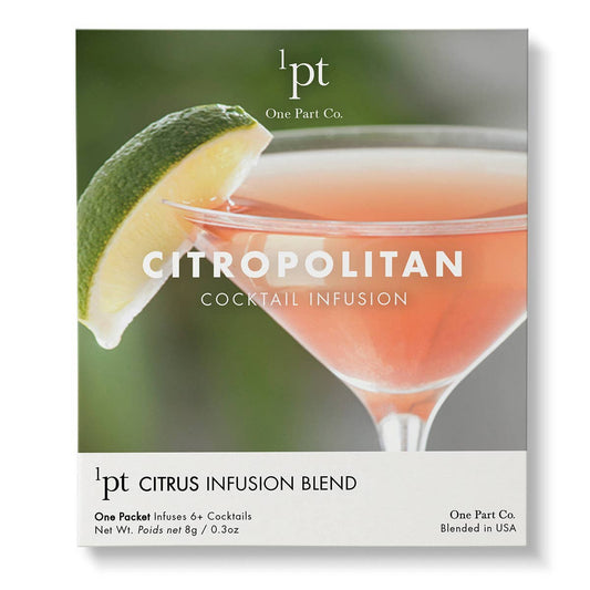 Citropolitan cocktail infusion packet with lime wedge and peachy-orange colored drink in a coupe glass