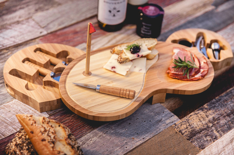 Bamboo golf club-shaped cheese board with red flag marker, swing-out drawers holding stainless steel utensils, styled with cured meats, cheese, and crackers on wooden surface