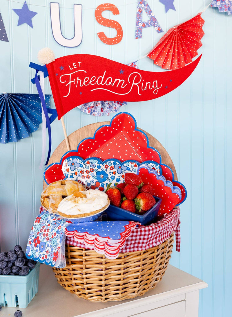 Red felt pennant banner reading "Let Freedom Ring" with white script lettering, displayed above patriotic blue and red decorative bunting.