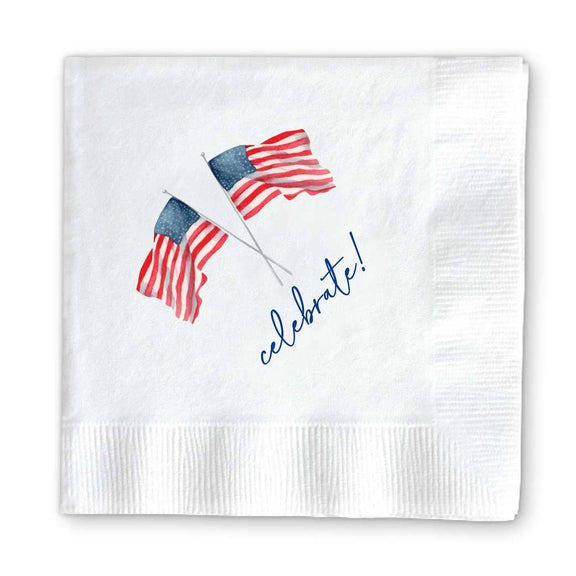 White cocktail napkin featuring two waving American flags and "celebrate!" text in navy cursive lettering