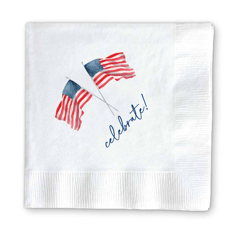 White cocktail napkin featuring two waving American flags and "celebrate!" text in navy cursive lettering