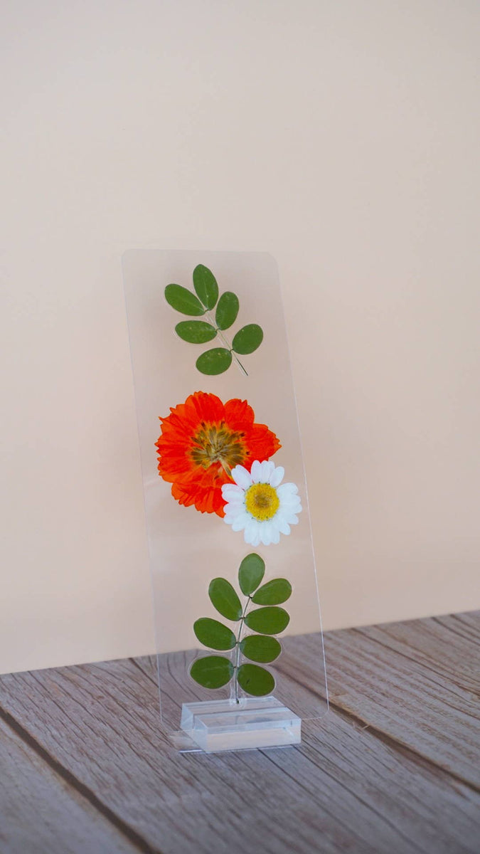 Pressed floral bookmark with red dahlia, white daisy, and green leafy stem on clear resin card