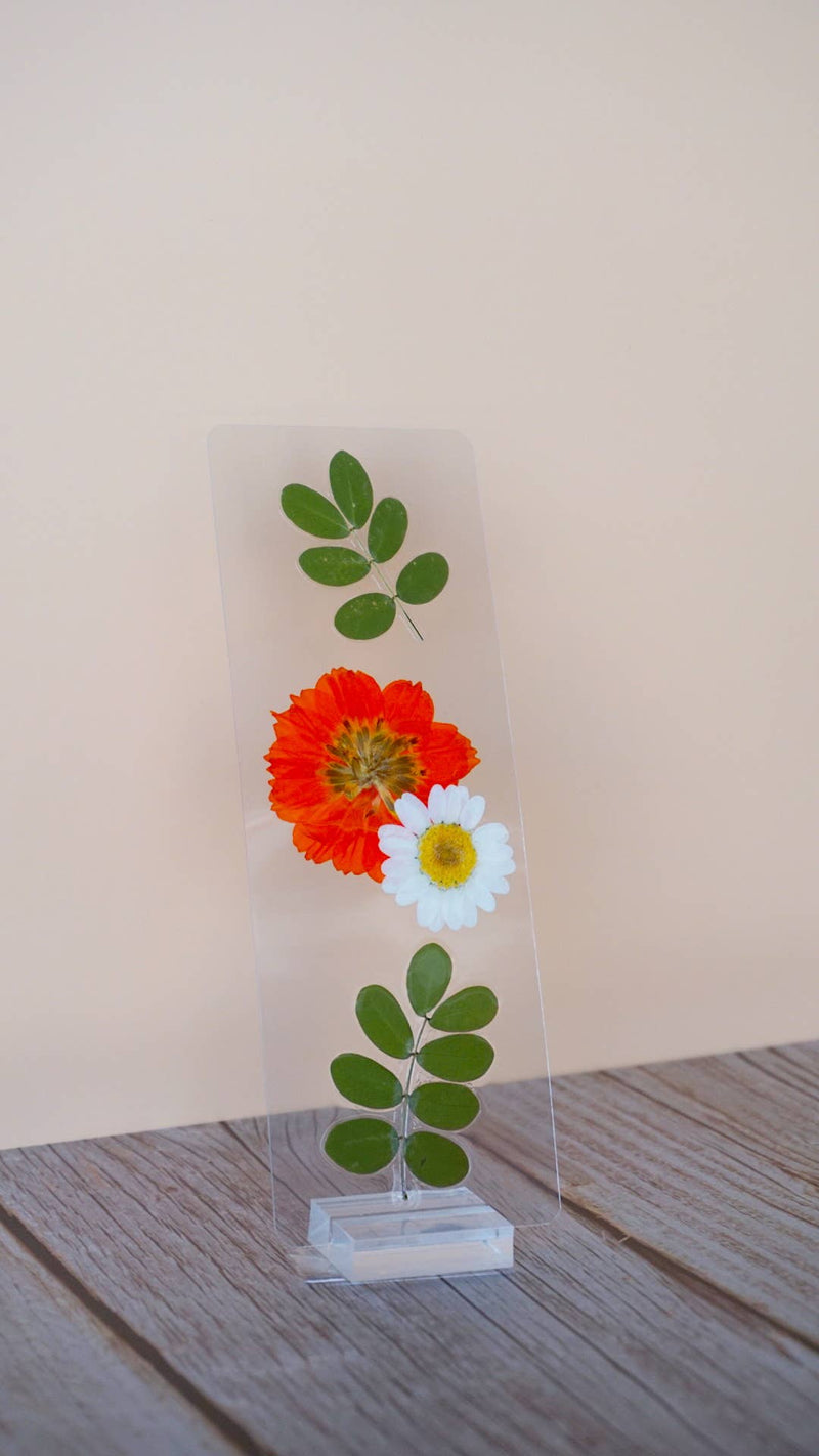 Pressed floral bookmark with red dahlia, white daisy, and green leafy stem on clear resin card