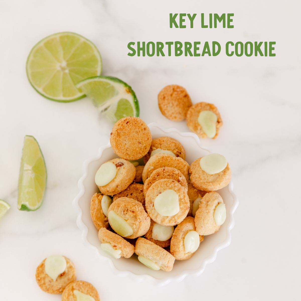 Golden key lime shortbread cookies with white chocolate chips, garnished with fresh lime slices on a white plate