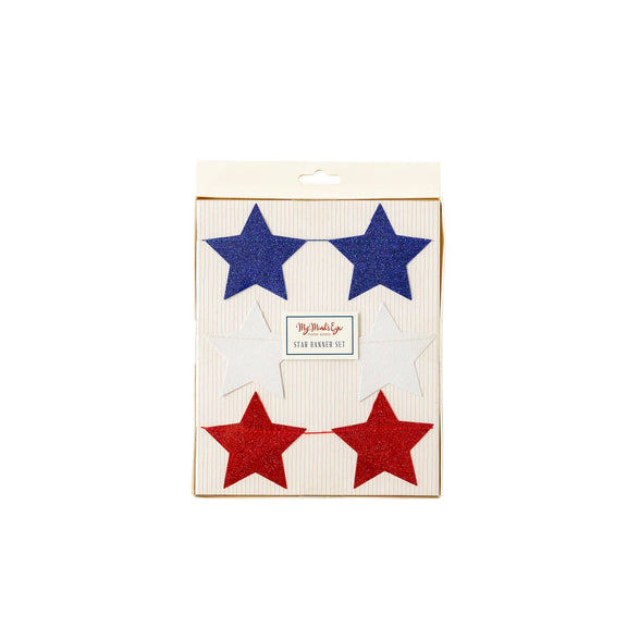 Red, white, and blue glitter star banner set on cream packaging with six stars connected by string for 4th of July decorations.