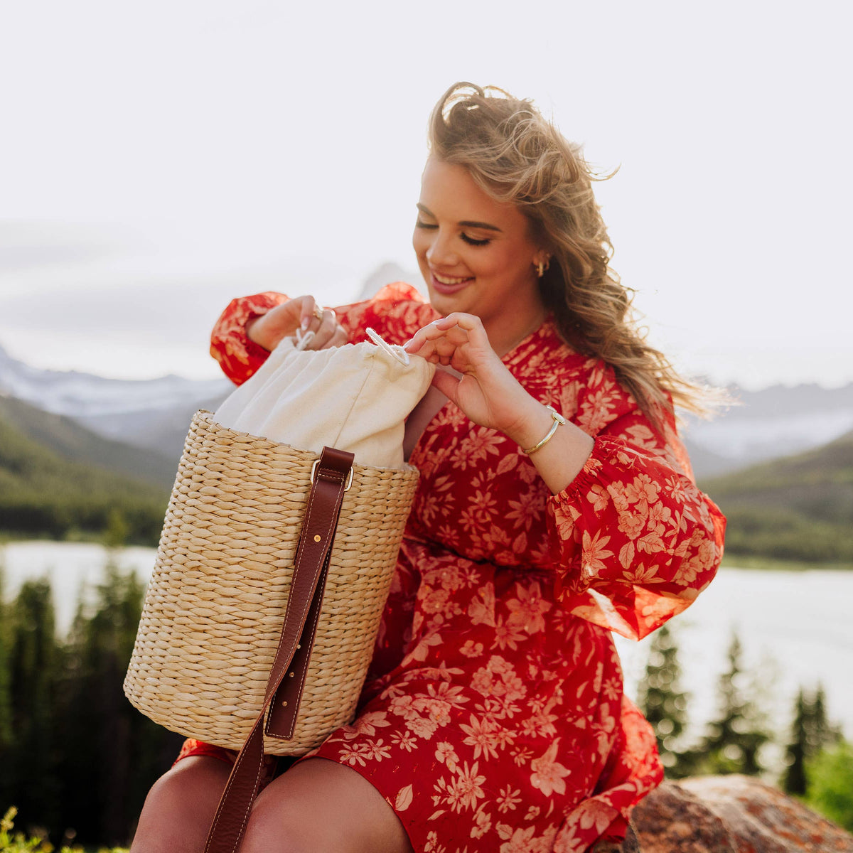 Beige handwoven rush tote with brown leather shoulder strap, displayed open with cream lining